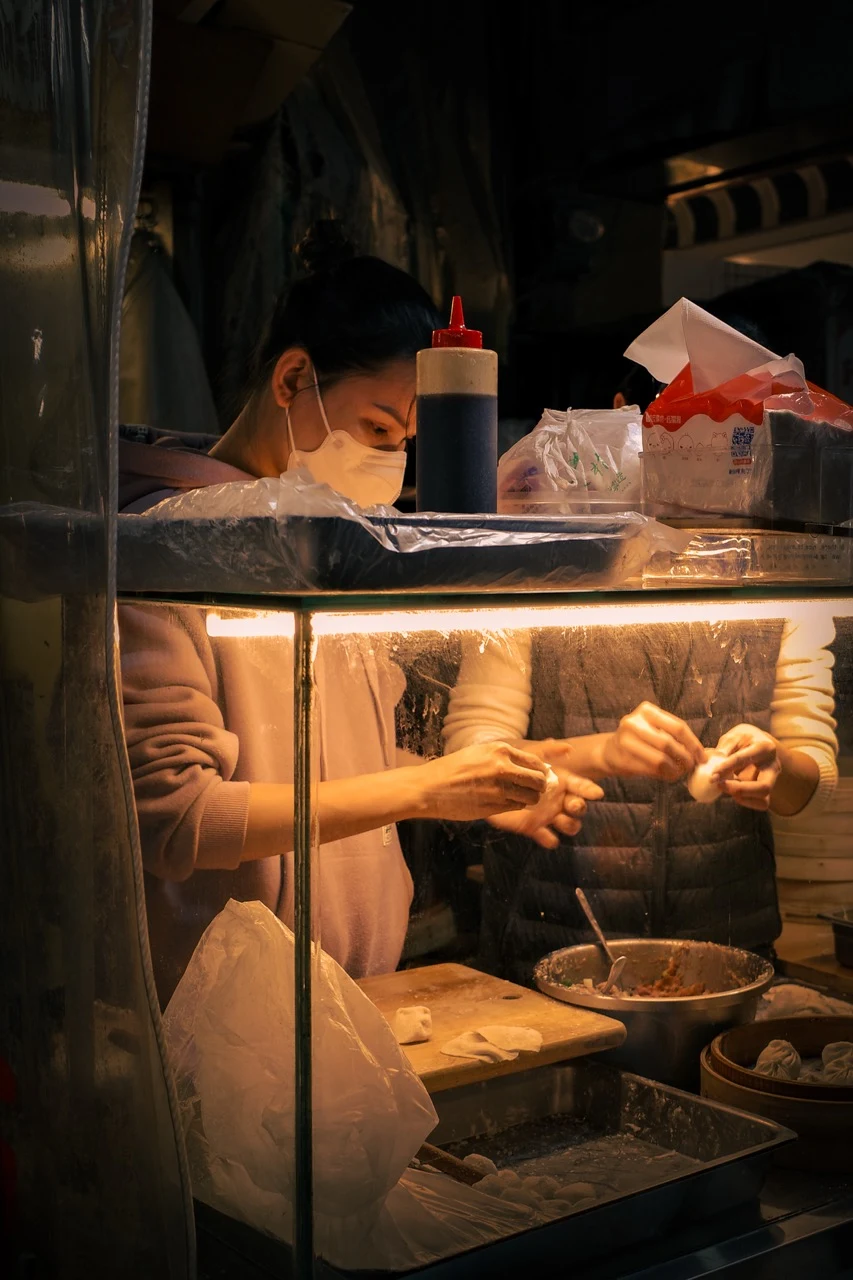 Preparing food at a warmly lit street stall
